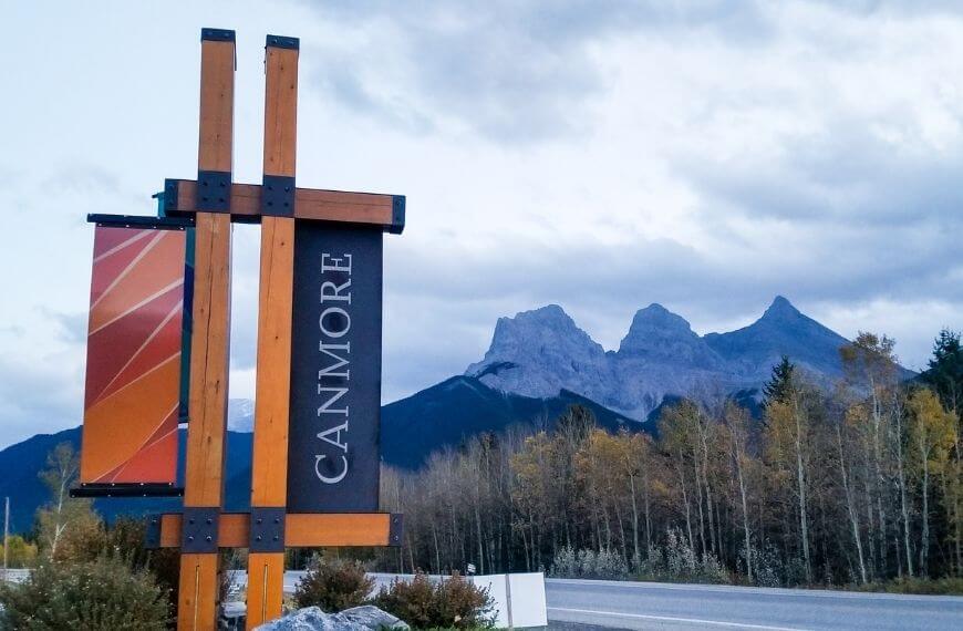 Canmore town sign with three sisters in background