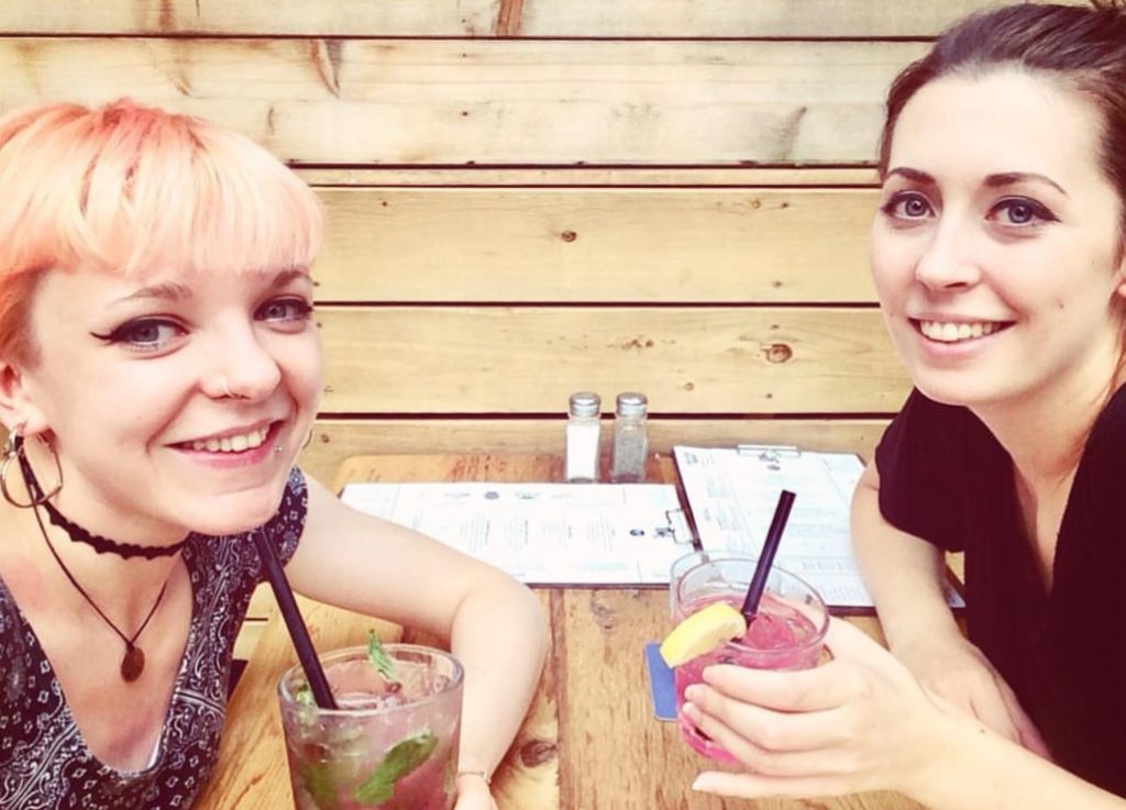 two friends in a bar drinking cocktails