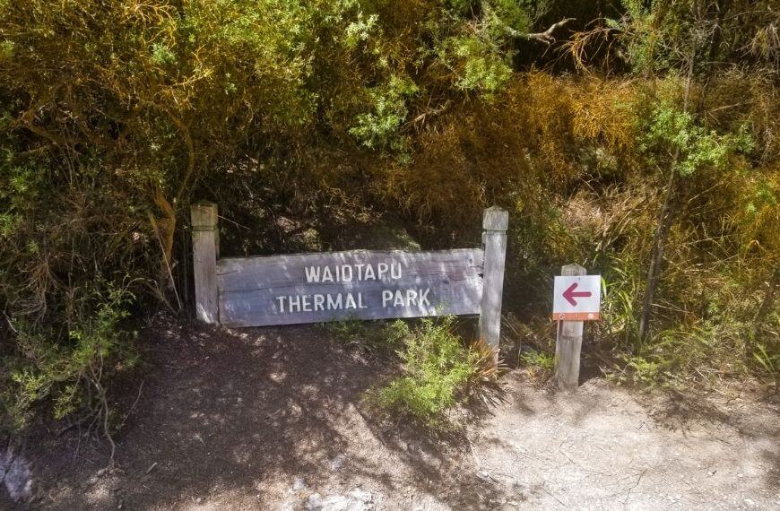 wooden sign that says "wai-o-tapu" in the thermal wonderland