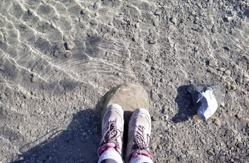 hiking boots in a clear water lake - hiking captions