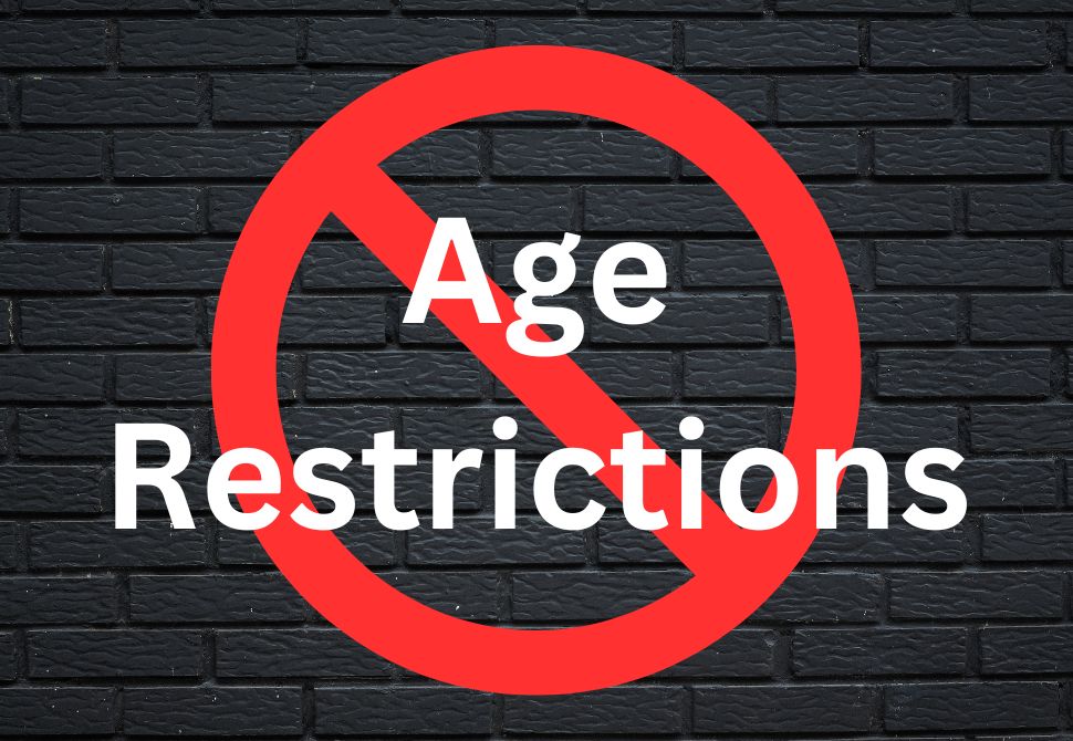 a black brick wall with a red warning sign and "age restrictions" written in white graphic - disadvantages of staying in a hostel