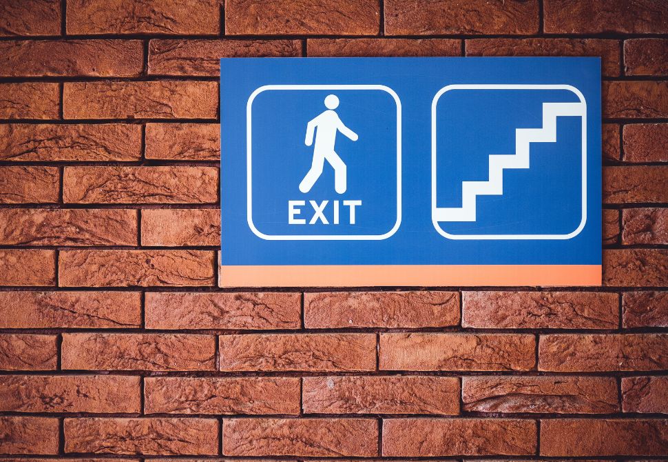 exit sign with a stick man and some stairs - something that should give peace of mind when asking are hostels dangerous