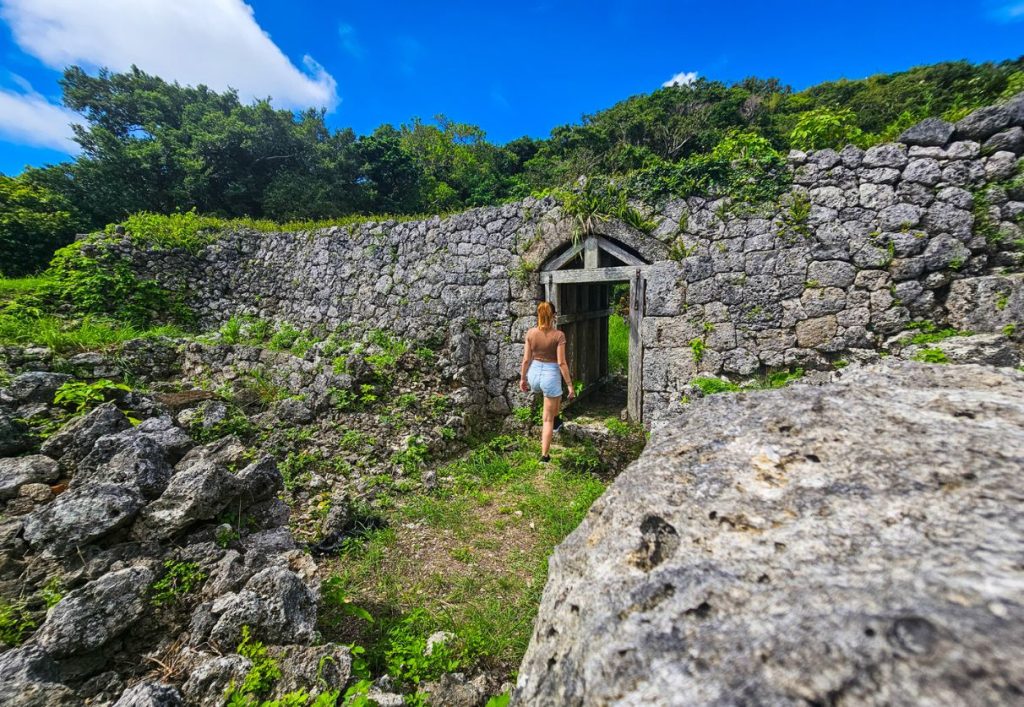 Me walking through a small standing doorway of Chinen Castle, one of the castles with ruins in Okinawa
