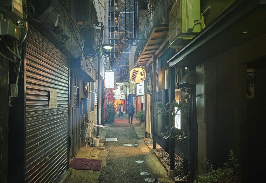an unsuspecting alley way that livens up as one of the busiest in fukuoka