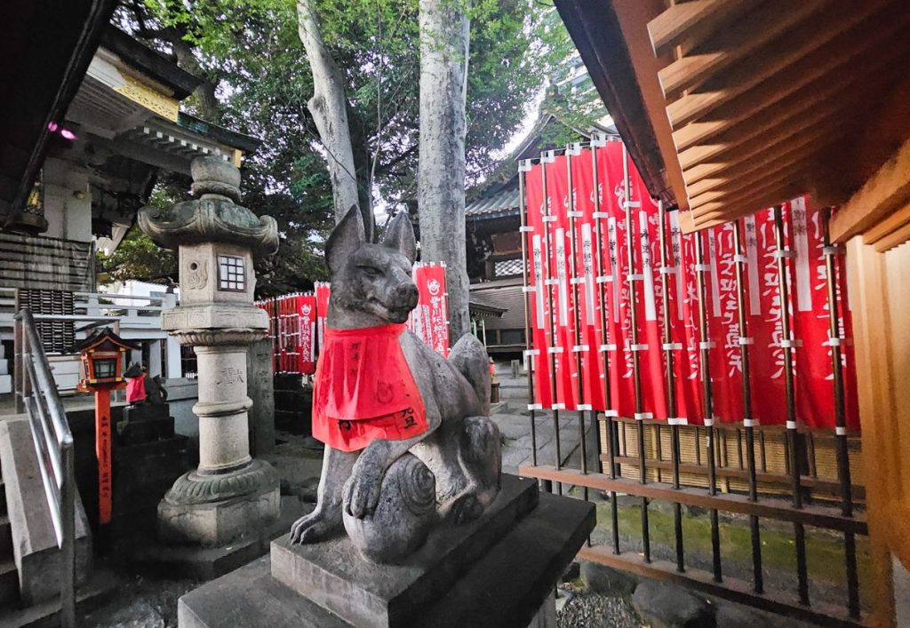 Famous red bib on fox statues at the fox shrine in Tokyo