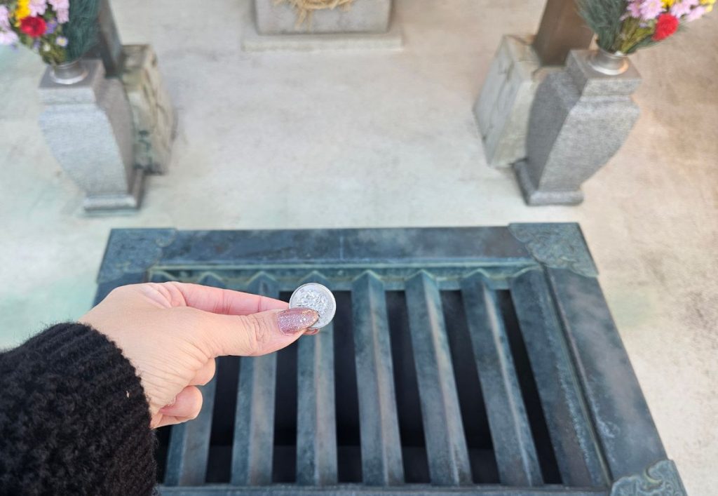 Me about to put a 1x yen coin into the silver box as an offering