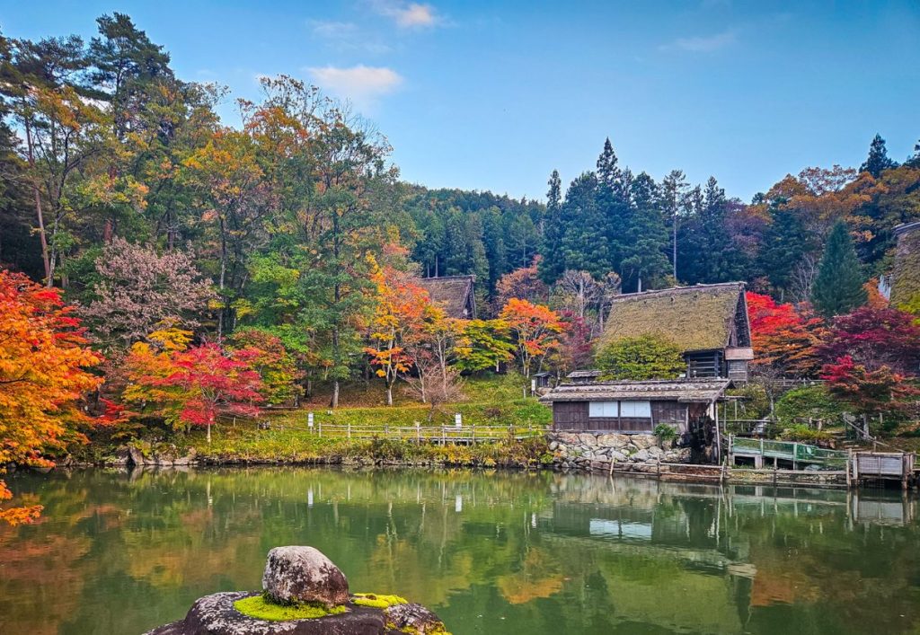 The small pond with maple leaves and two of the traditional houses